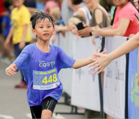 Kid-giving-high-five-to-spectators-while-running